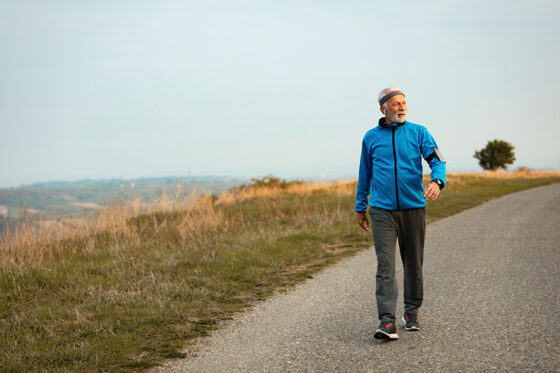 full length senior sportsman taking walk morning listening music earphones nature copy space 560x373jpg