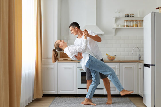 happy couple dancing kitchen husband wife wearing white shirts dance morning near window expressing love romantic feelings indoor shot 560x373jpg