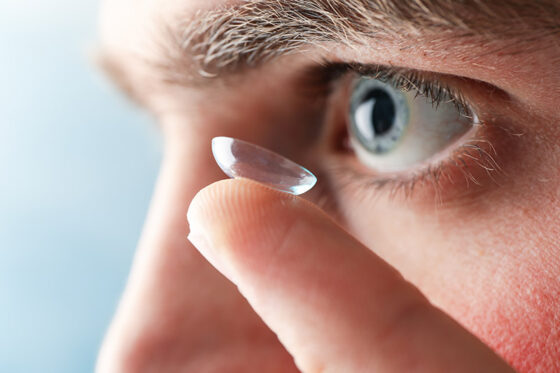 inserting corrective contact lens man with blue eyes 560x373jpg