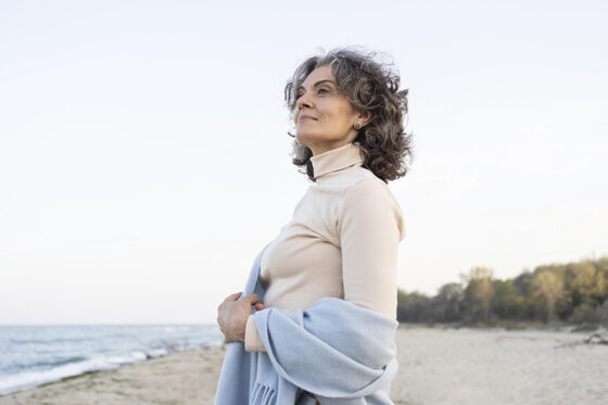 older woman enjoying her time beach 560x373jpg