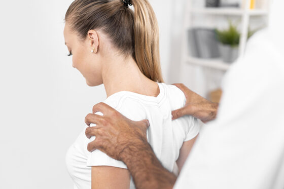 male physiotherapist checking woman s back shoulders 560x373jpg