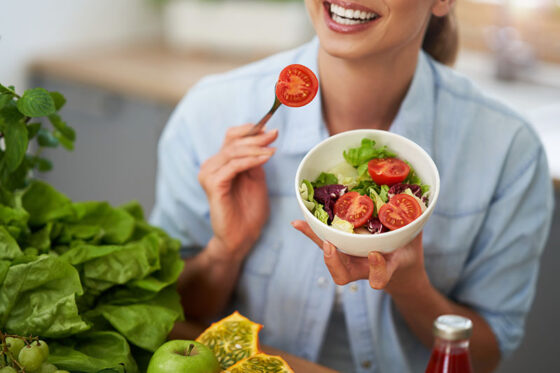 healthy adult woman with green food kitchen 560x373jpg